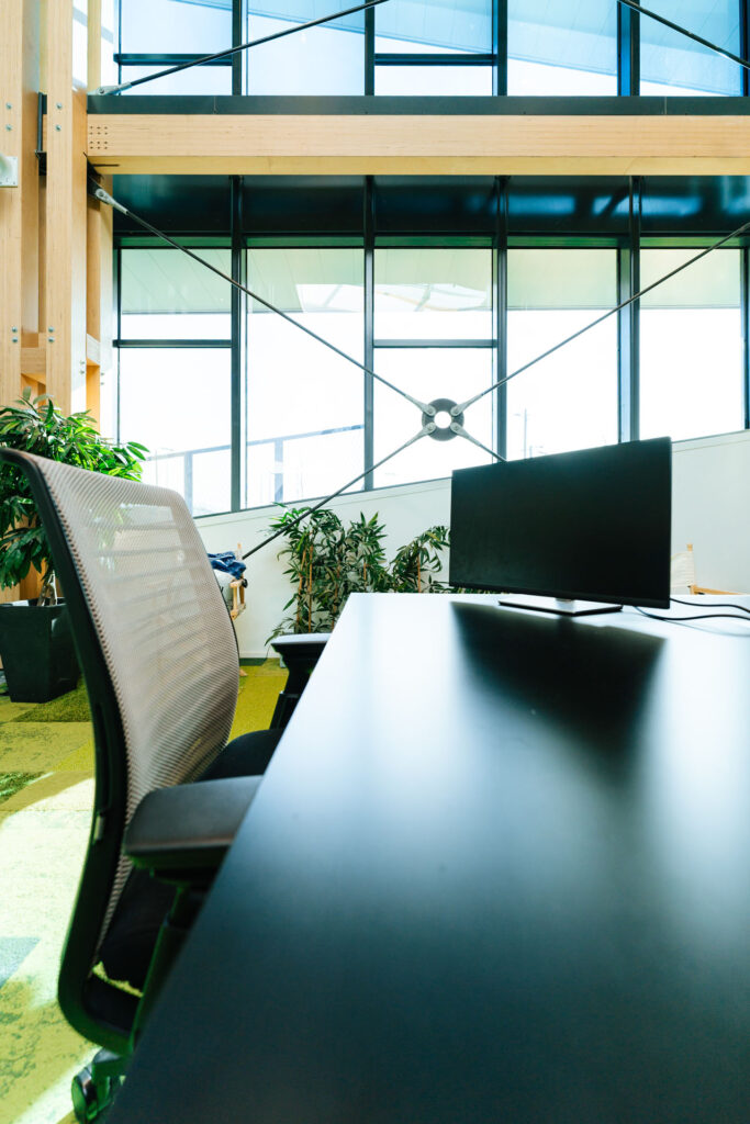 Modern workspace at Voyage Privé HQ, featuring a sleek desk, computer setup, and greenery for a vibrant work environment.