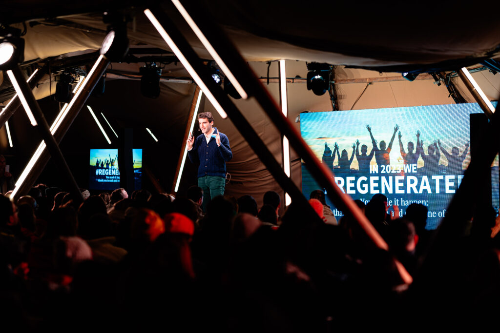 A speaker addresses an engaged audience at an inspiring event, highlighting teamwork and innovation for Voyage Privé.